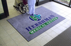 baltimore washington mat service a nurse walks on an entrance mat labeled "Hershman Medical Center" with the hospital logo imprinted.